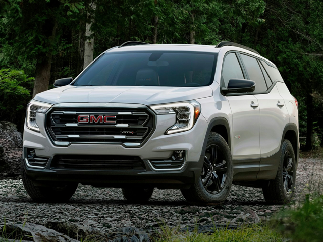 White 2023 GMC Terrain driving through trees.